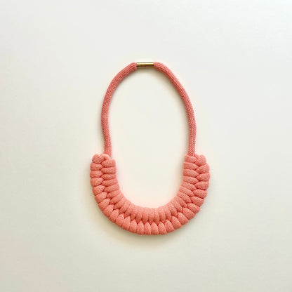 A peach coloured, knotted necklace using the figure 8. The golden-look clasp is a sleek, minimal design. Made from 100% recycled cotton that is manufactured in the UK.